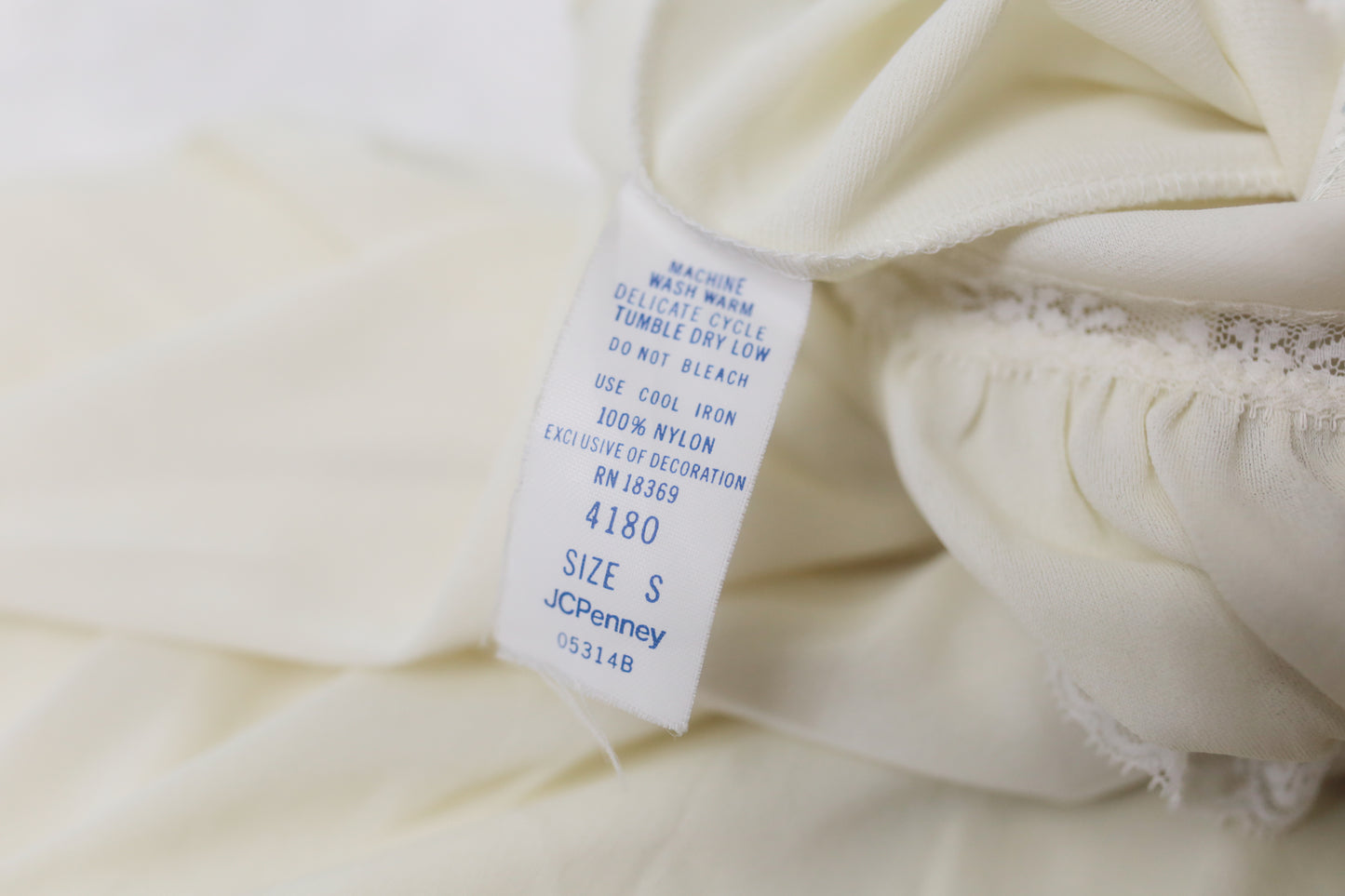 Close-up of a white garment with a tag displaying 'JCPenney' on a white background