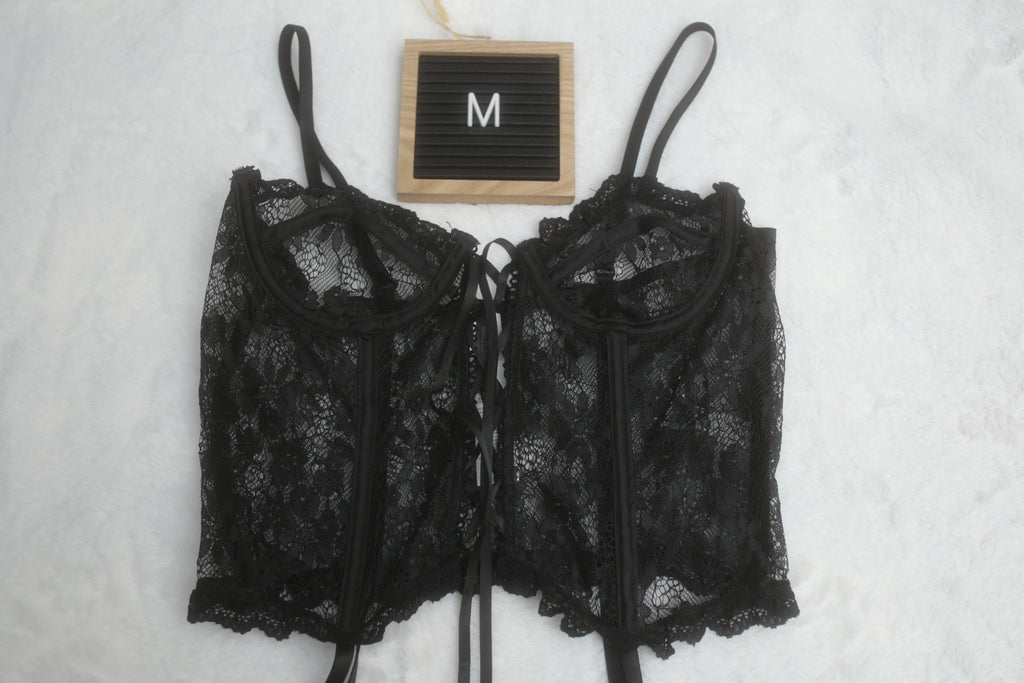 A black floral lace corset lingerie top with adjustable straps, attached garter straps, and underwire support. The letter 'M' indicates the size is medium.