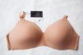 A beige seamless wireless contour t-shirt bra with adjustable straps and a tag visible