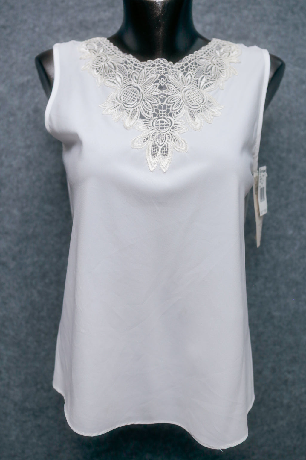 White sleeveless top with lace neckline on a mannequin against a gray background